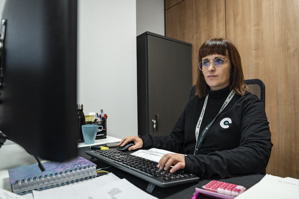 Hospital front-desk receptionist working at a computer at the reception counter